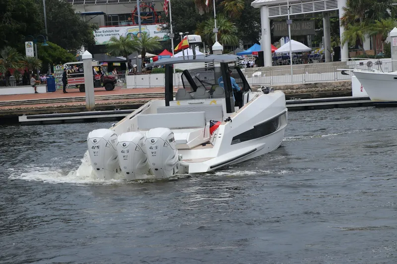 Slide: The Image of 2024 Astondoa 377 Coupe Outboard cruising in a marina with triple engines. - 6