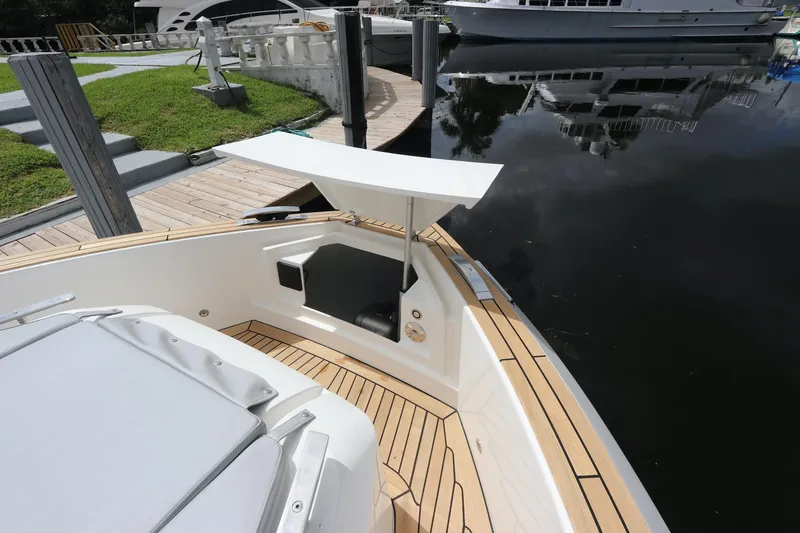 Slide: The Image of 2024 Astondoa 377 Coupe Outboard, sleek deck design by the water. - 12