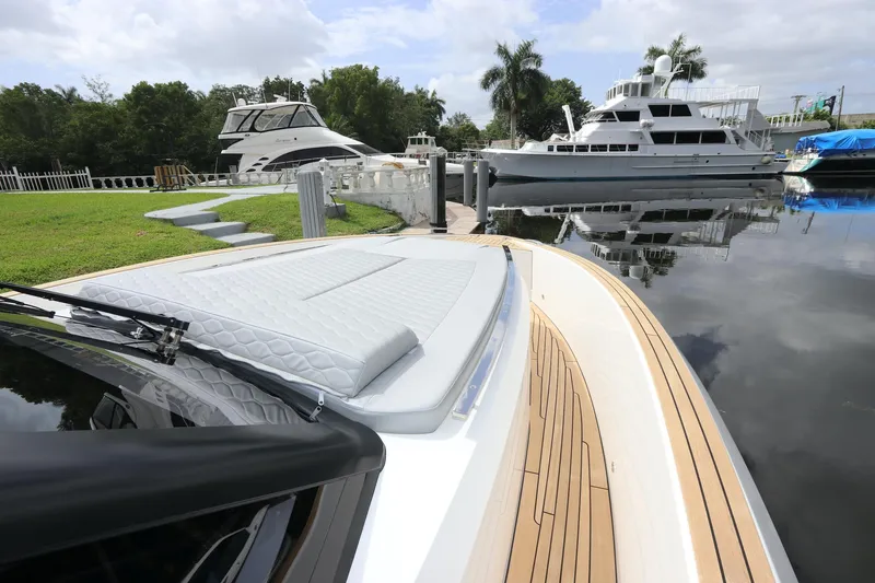 Slide: The Image of 2024 Astondoa 377 Coupe Outboard docked near luxury yachts on a calm waterfront. - 18