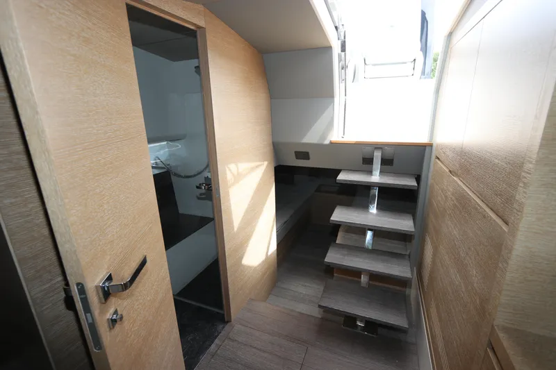 Slide: The Image of Interior of 2024 Astondoa 377 Coupe Outboard, featuring modern wooden stairs and sleek design. - 35
