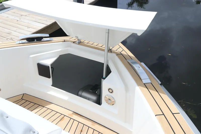 Slide: The Image of 2024 Astondoa 377 Coupe Outboard, open storage compartment, sleek design, wooden deck accents. - 13