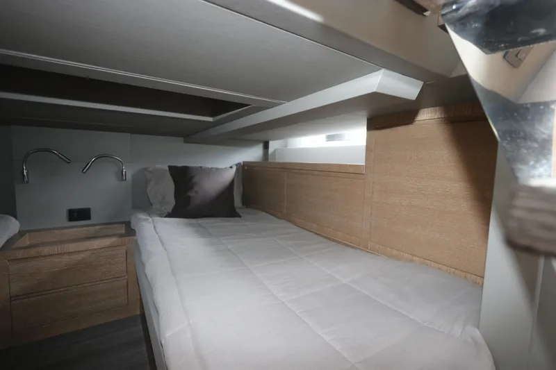 Slide: The Image of 2024 Astondoa 377 Coupe Outboard cabin interior with modern bedding and wood accents. - 42