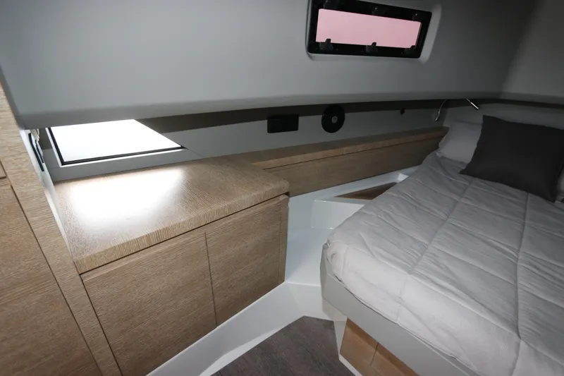 Slide: The Image of 2024 Astondoa 377 Coupe Outboard cabin interior with modern wood cabinetry and cozy bedding. - 38