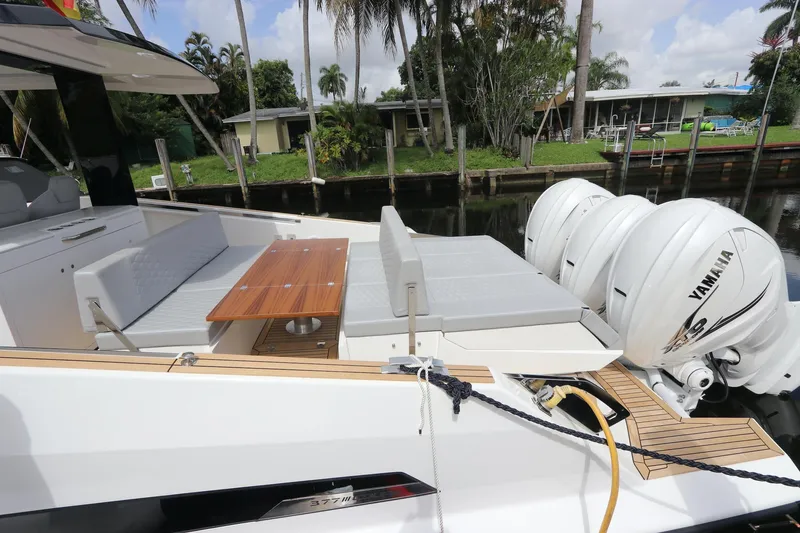 Slide: The Image of 2024 Astondoa 377 Coupe Outboard with Yamaha engines, featuring sleek seating and a wooden table. - 28