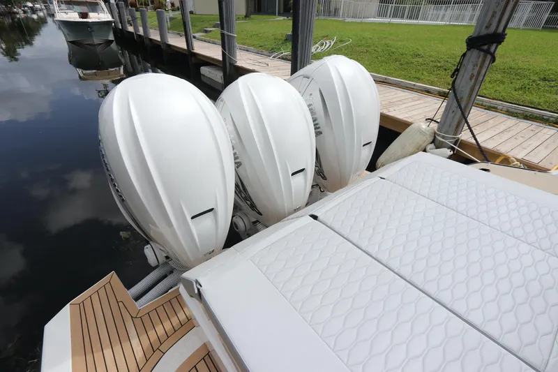 Slide: The Image of 2024 Astondoa 377 Coupe Outboard with triple engines docked by wooden pier. - 33