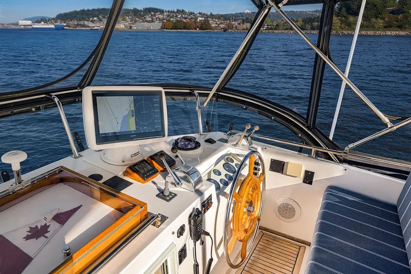 Slide: The Image of Helm of 2002 Grand Banks 46 Classic yacht with navigation equipment and scenic water view. - 26