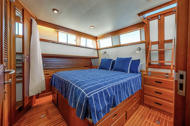 Slide: The Image of Luxurious 2002 Grand Banks 46 Classic yacht bedroom with wood accents and blue bedding. - 11