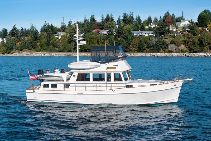 The Image of Grand Banks 46 Classic yacht cruising on blue water near a scenic shoreline, 2002 model. - 1