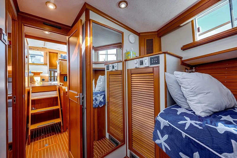 Slide: The Image of Interior of 2002 Grand Banks 46 Classic yacht with cozy wooden cabin and bedding. - 19