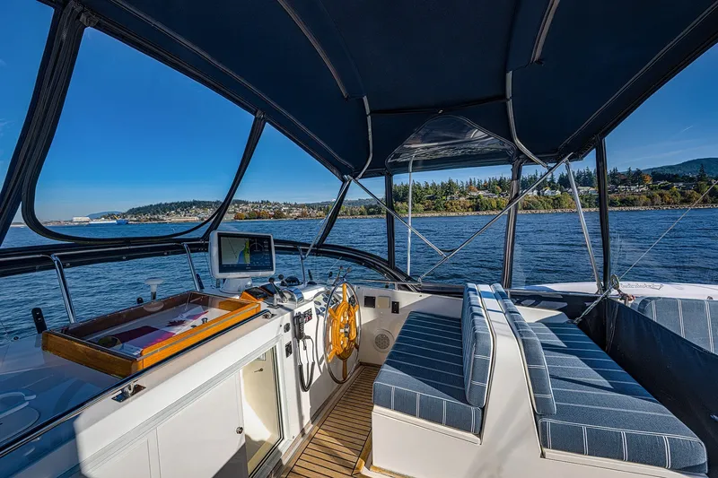 Slide: The Image of Interior view of 2002 Grand Banks 46 Classic yacht helm with scenic water backdrop. - 25