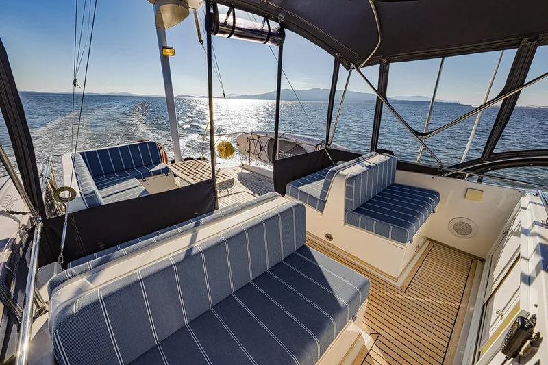 Slide: The Image of Luxurious 2002 Grand Banks 46 Classic yacht interior with striped seating, cruising on open water. - 27