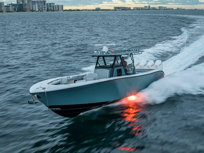 Slide: The Image of Ein 2024er Yellowfin 39 Offshore Boot fährt schnell über das Wasser, mit einer Stadt im Hintergrund. - 7
