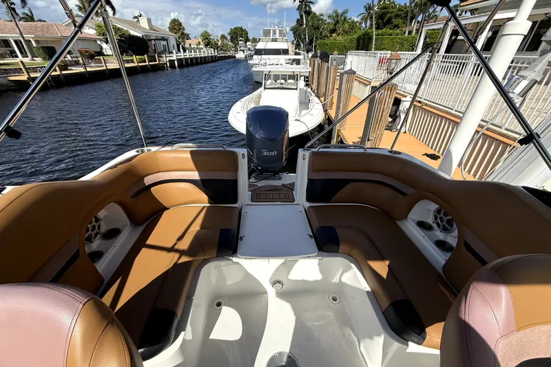 Slide: The Image of 2019 Hurricane SunDeck 2486 OB boat with tan seating, docked by a canal. - 3
