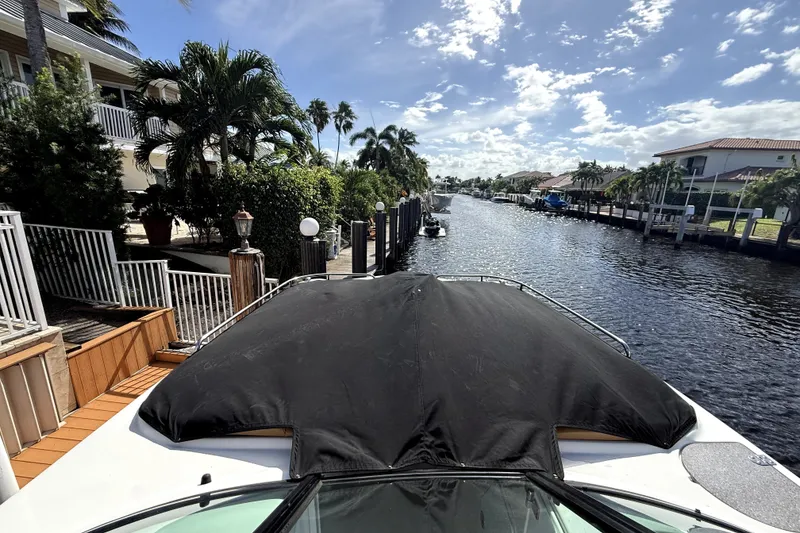 Slide: The Image of 2019 Hurricane SunDeck 2486 OB docked by a scenic canal with palm trees. - 1