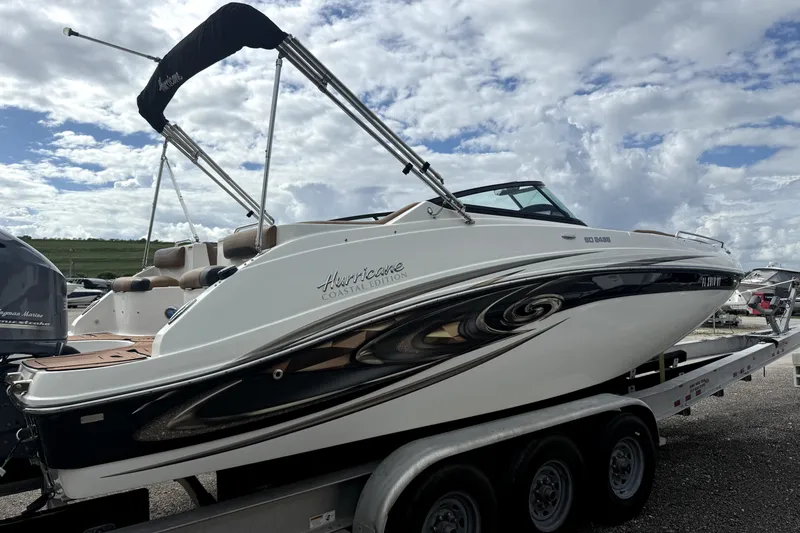 Slide: The Image of 2019 Hurricane SunDeck 2486 OB boat on trailer under cloudy sky. - 15