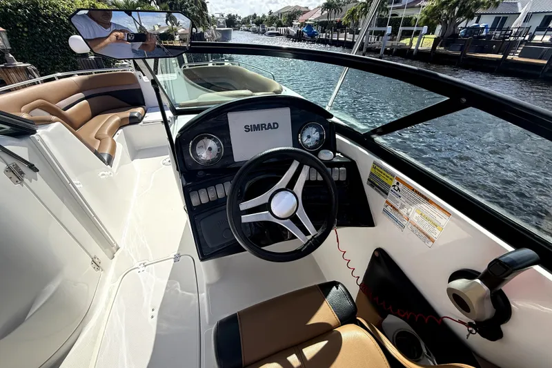 Slide: The Image of 2019 Hurricane SunDeck 2486 OB boat interior with steering wheel and Simrad display. - 14