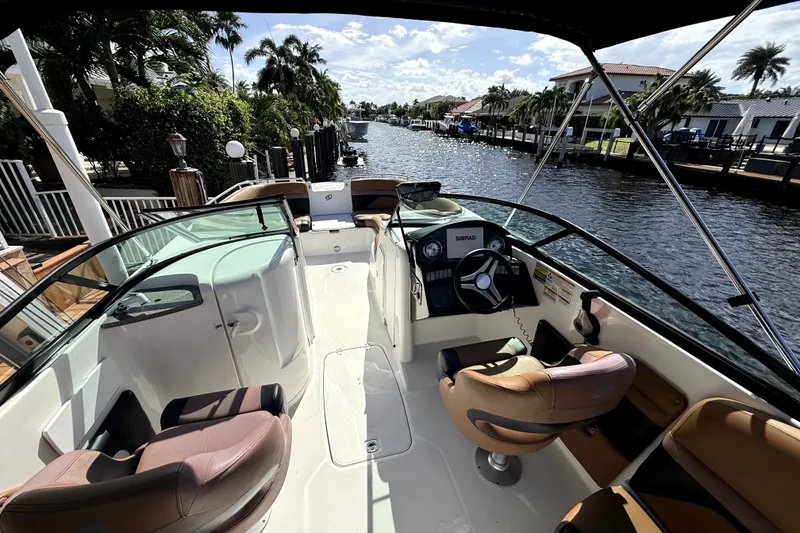 Slide: The Image of 2019 Hurricane SunDeck 2486 OB boat interior with steering wheel, seats, and waterway view. - 4