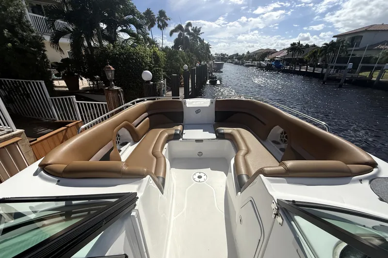 Slide: The Image of 2019 Hurricane SunDeck 2486 OB boat with spacious seating, docked by a scenic canal. - 16