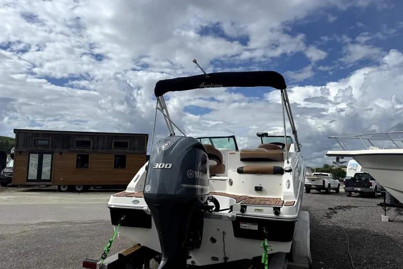 Slide: The Image of 2019 Hurricane SunDeck 2486 OB boat with Yamaha 300 engine, parked outdoors under cloudy sky. - 13