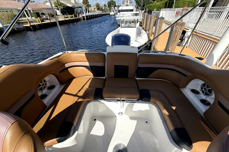 Slide: The Image of 2019 Hurricane SunDeck 2486 OB boat interior with tan seating and waterfront view. - 2