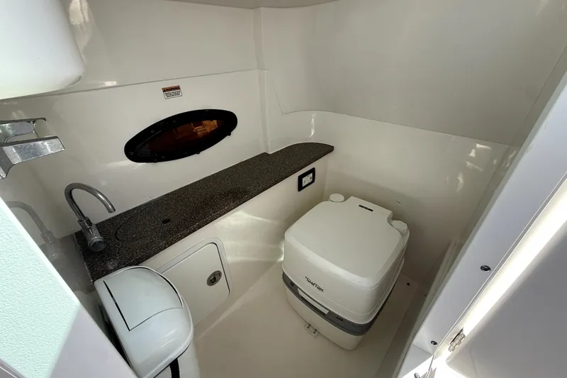 Slide: The Image of 2019 Hurricane SunDeck 2486 OB boat interior with sink and portable toilet. - 9