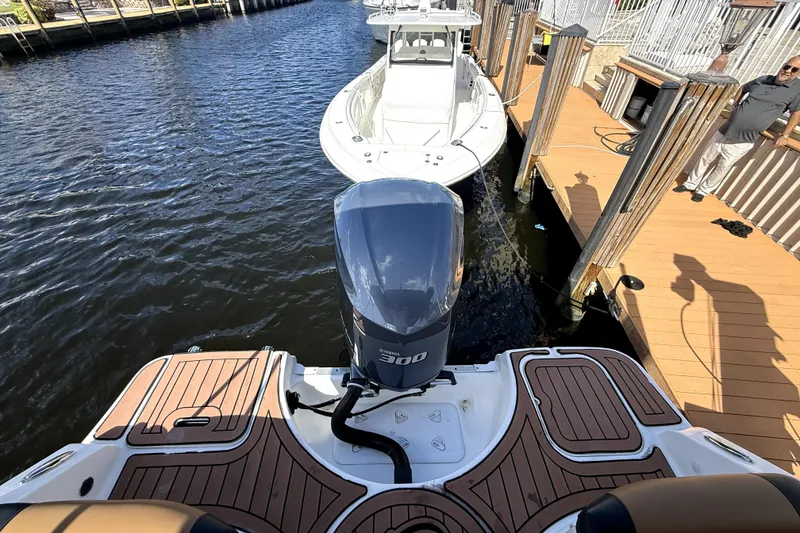 Slide: The Image of 2019 Hurricane SunDeck 2486 OB docked, featuring a powerful outboard motor. - 6