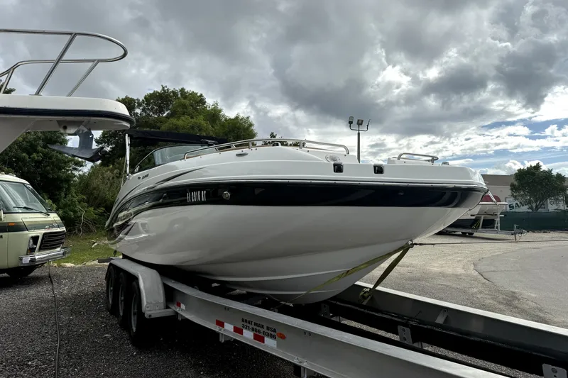 Slide: The Image of 2019 Hurricane SunDeck 2486 OB boat on trailer under cloudy sky. - 7