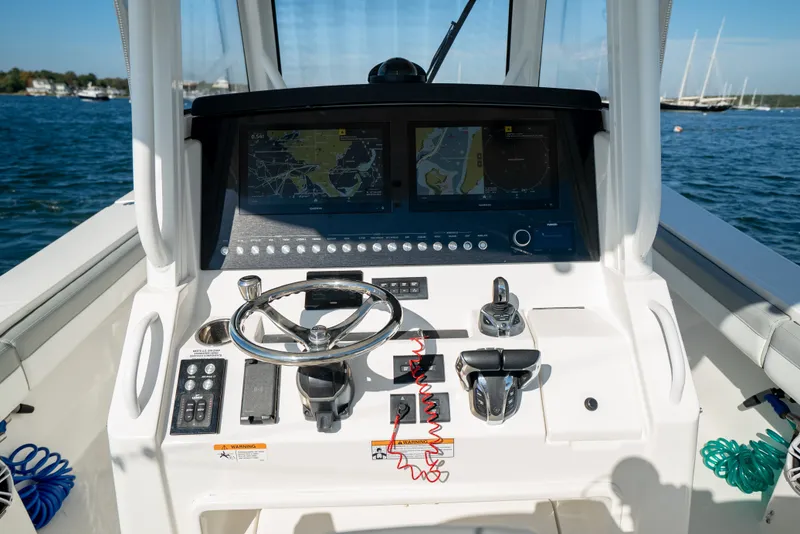 Slide: The Image of The cockpit of a 2022 Regulator 34 CC with modern navigation systems and controls. - 26