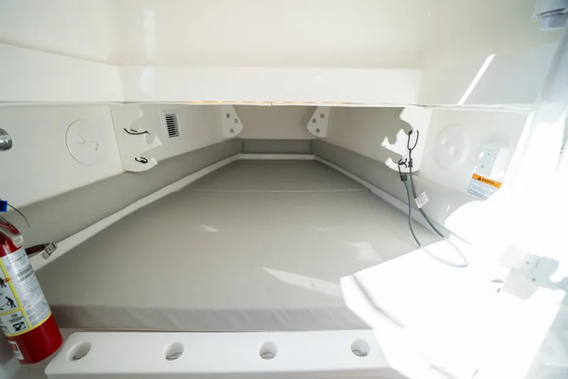 Slide: The Image of Interior of a 2022 Regulator 34 CC with cushioned sleeping area and fire extinguisher. - 36