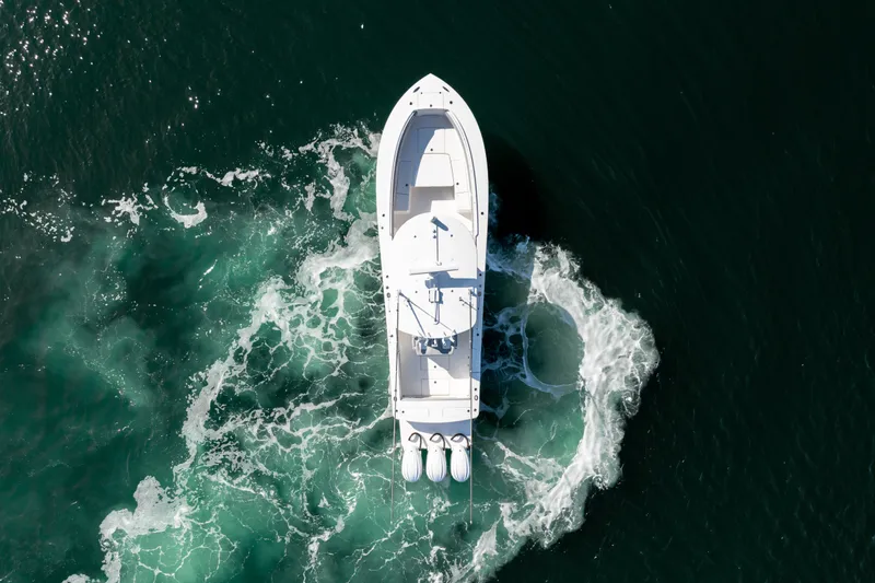 Slide: The Image of Aerial view of a white boat making a sharp turn on the water, with visible waves. - 13