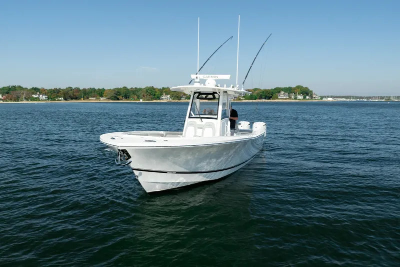 Slide: The Image of 2022 Regulator 34 CC on calm water with two fishing rods and clear skies. - 2