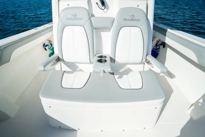 Slide: The Image of Two cushioned seats with armrests and cup holders on a boat, surrounded by water. - 21