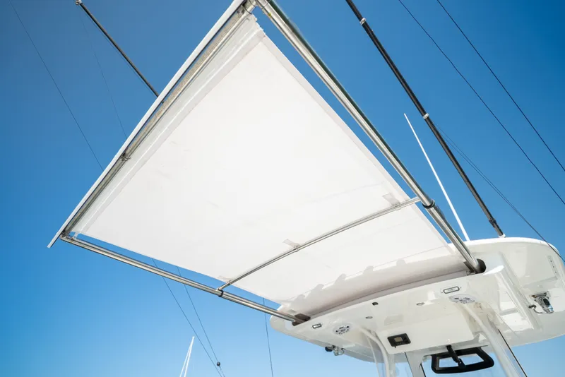 Slide: The Image of A sunshade on a 2022 Regulator 34 CC boat, set against a clear blue sky. - 33