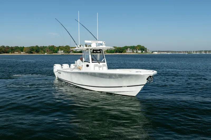 Slide: The Image of 2022 Regulator 34 CC on calm water with fishing rods and clear blue sky. - 10