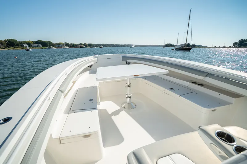 Slide: The Image of Regulator 34 CC 2022: Spacious bow area with table and benches, on calm water. - 17