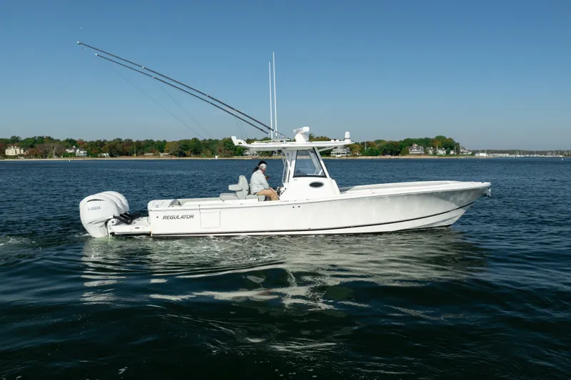 Slide: The Image of A white motorboat on calm water, featuring two outboard engines and fishing rods. - 8