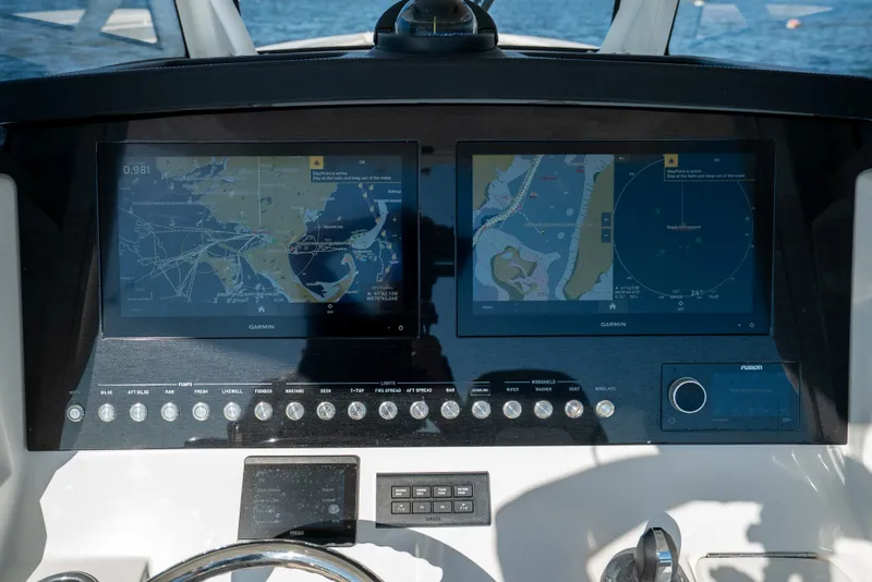 Slide: The Image of The dashboard of a Regulator 34 CC boat with two large navigation screens. - 27