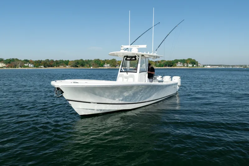 Slide: The Image of A white boat, Regulator 34 CC model, cruising on calm water with two fishing rods. - 3