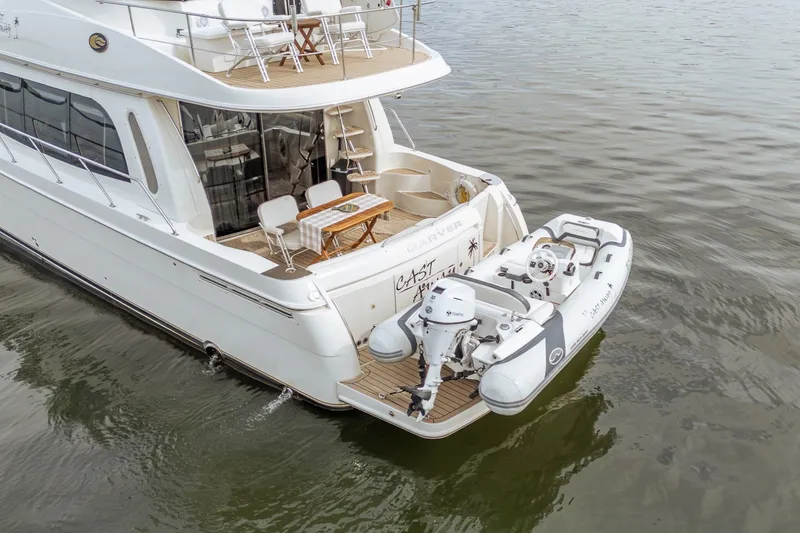 Slide: The Image of 2006 Carver 56 Voyager yacht with attached dinghy on calm water. - 16