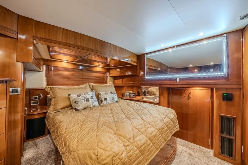 Slide: The Image of Luxurious bedroom interior of 2006 Carver 56 Voyager yacht with wood paneling and cozy bedding. - 58