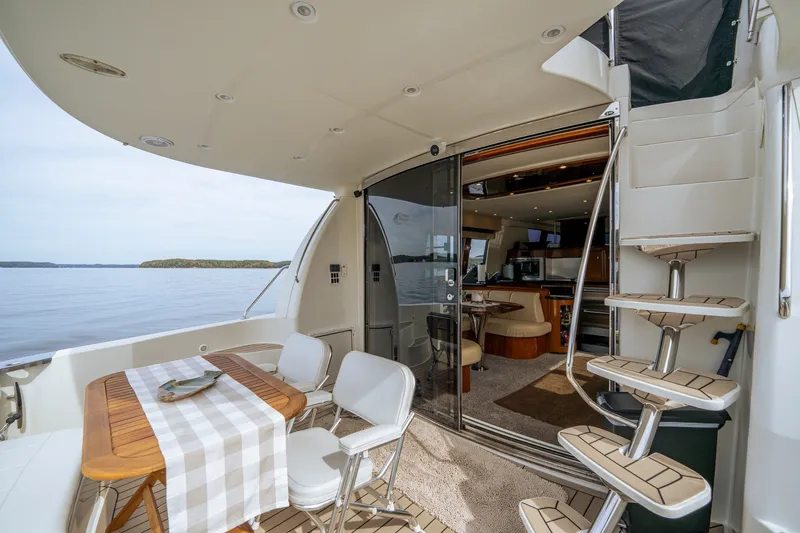 Slide: The Image of Luxurious 2006 Carver 56 Voyager yacht interior with dining area and spiral staircase. - 28
