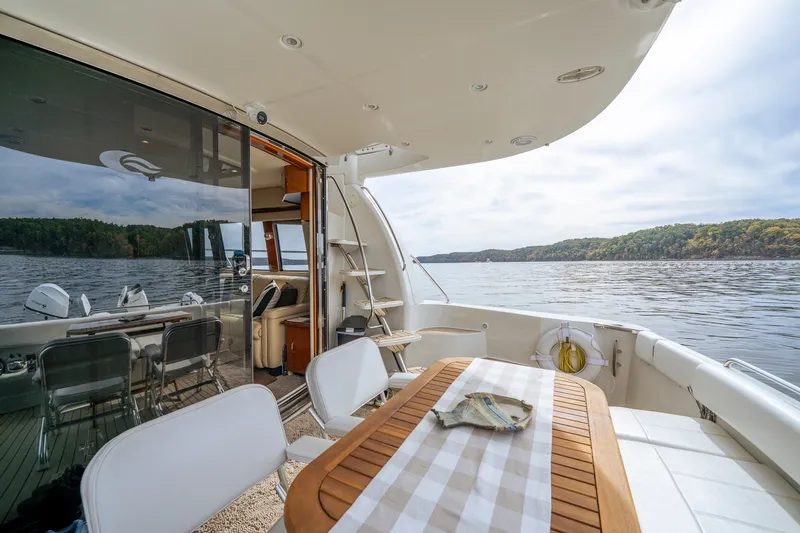 Slide: The Image of 2006 Carver 56 Voyager yacht deck with table, chairs, and scenic lake view. - 29