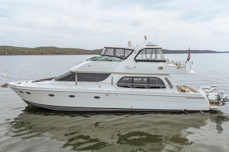 Slide: The Image of 2006 Carver 56 Voyager yacht on calm water, side view, with scenic background. - 18