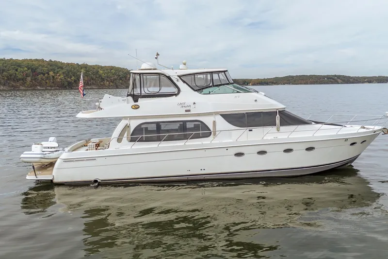 Slide: The Image of 2006 Carver 56 Voyager yacht on calm water with scenic background. - 22
