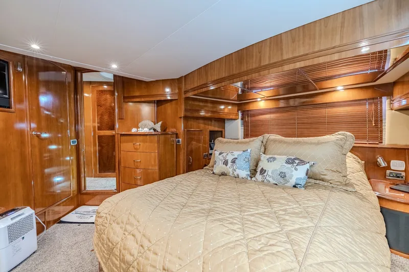 Slide: The Image of Luxurious 2006 Carver 56 Voyager yacht bedroom with elegant wood finish and cozy bedding. - 54