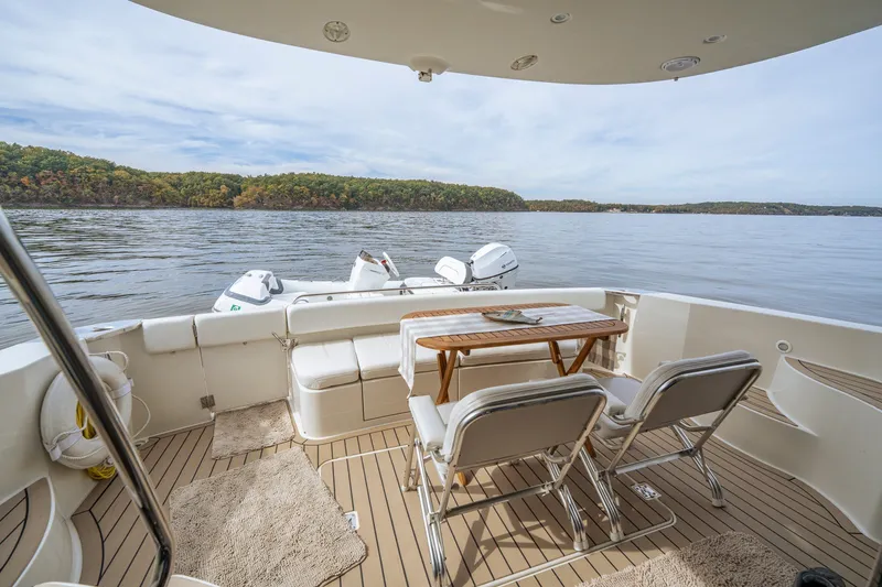Slide: The Image of 2006 Carver 56 Voyager yacht deck with chairs, table, and scenic lake view. - 31