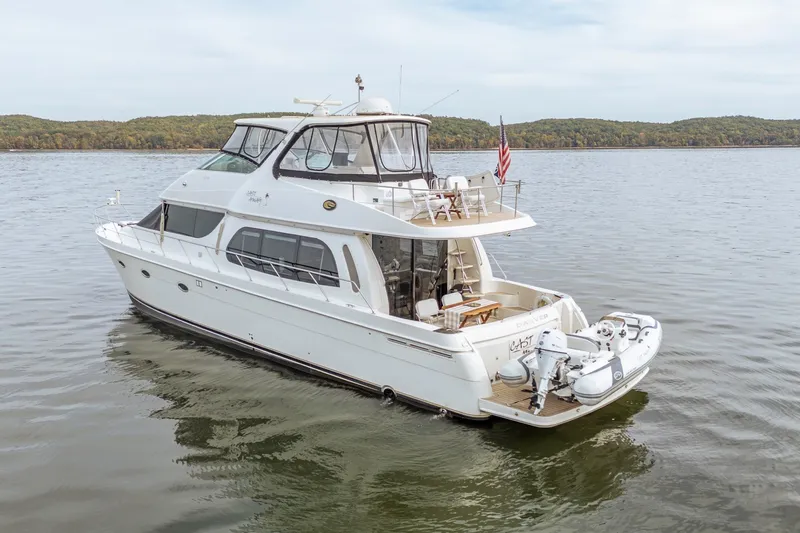 Slide: The Image of 2006 Carver 56 Voyager yacht on calm water with scenic background. - 17