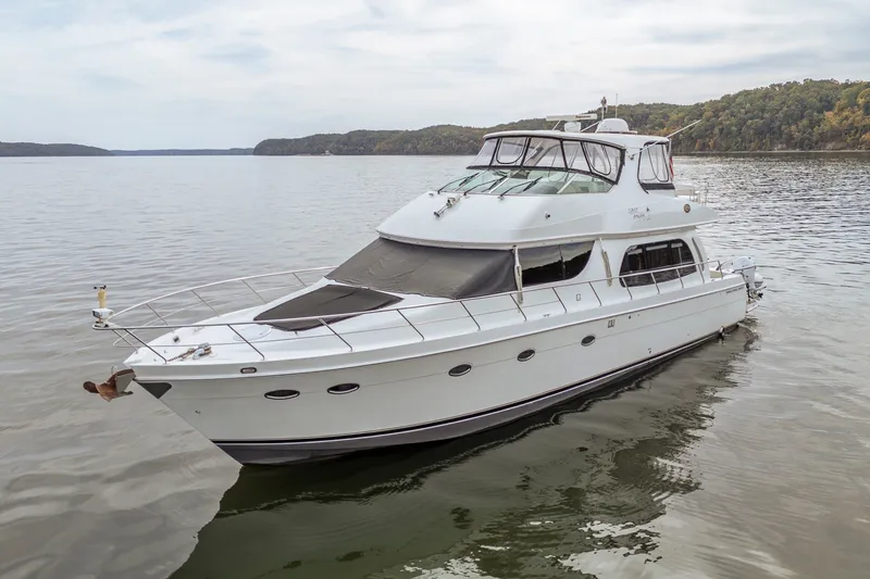 Slide: The Image of 2006 Carver 56 Voyager yacht on calm water with scenic background. - 19