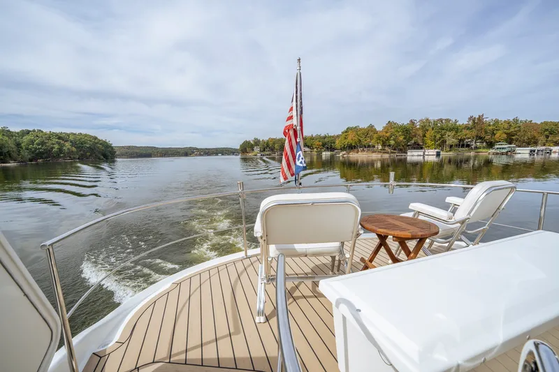 Slide: The Image of 2006 Carver 56 Voyager yacht deck with chairs, table, and scenic lake view. - 52