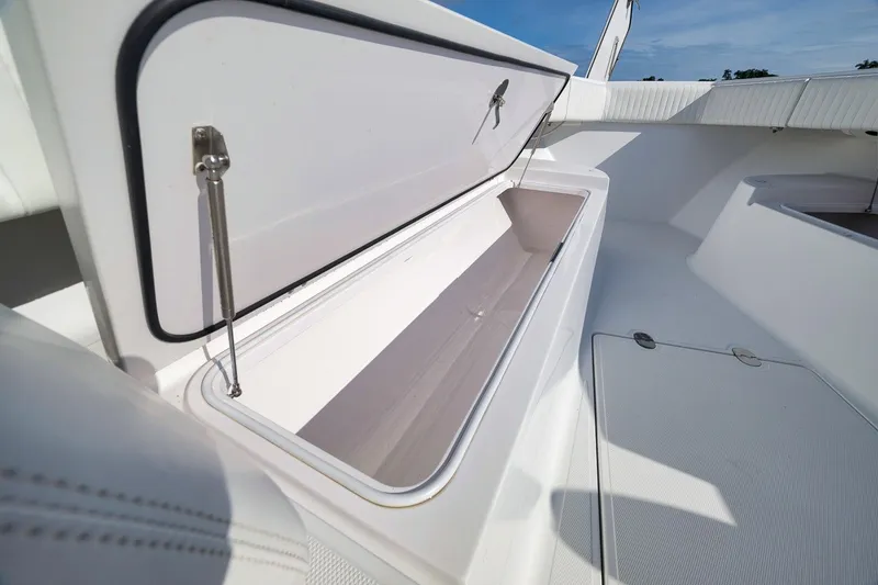 Slide: The Image of Open storage compartment on 2020 Bahama 41 boat deck under clear blue sky. - 50